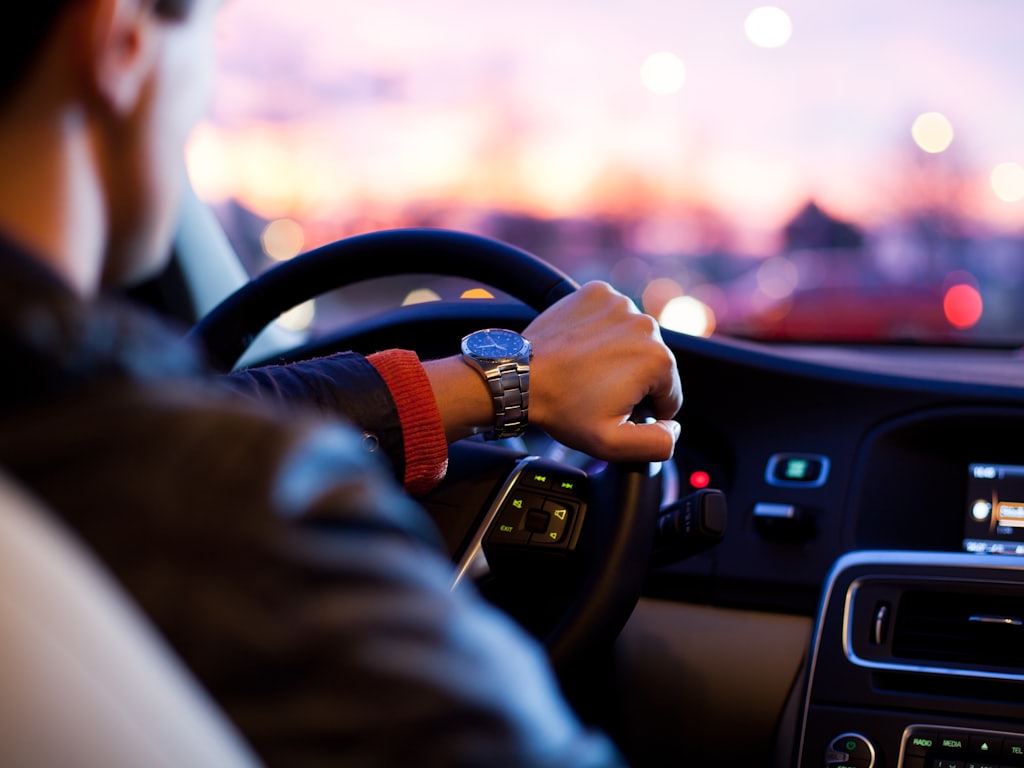 Persona al volante de su vehículo al atardecer